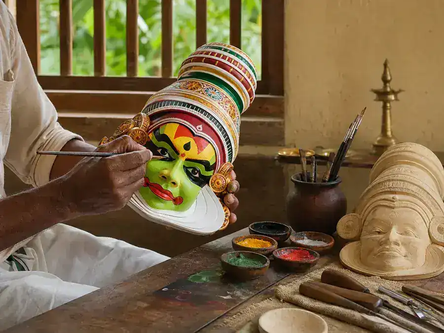 A Kerala artisan painting a traditional Kathakali mask by hand